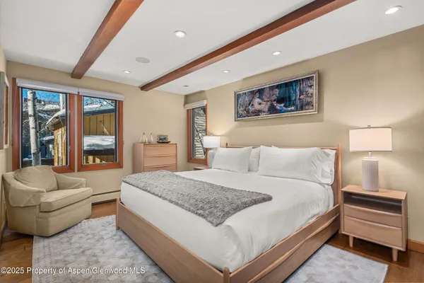 a spacious bedroom with a bed and a flat screen tv