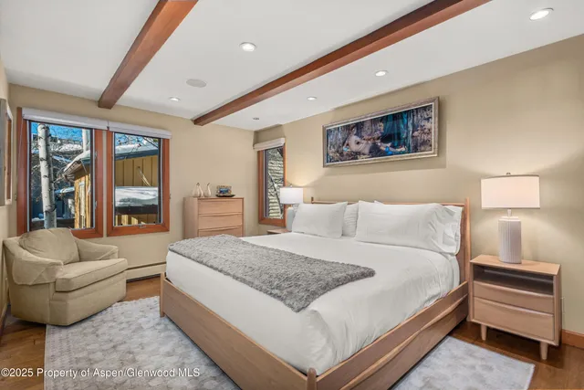 a spacious bedroom with a bed and a flat screen tv