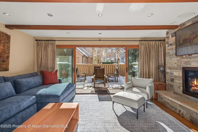 a living room with furniture a fireplace and a large window
