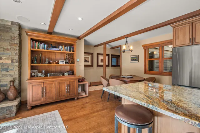 a dining hall with stainless steel appliances granite countertop a dining table and chairs with wooden floor