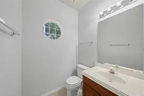 a bathroom with a granite countertop sink a toilet and a mirror