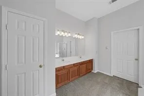 a spacious bathroom with a double vanity sink a mirror and a bathtub