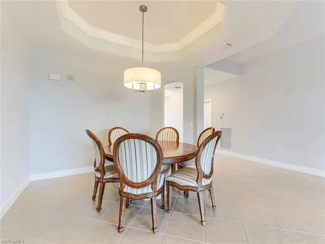 a dining room with furniture and large windows