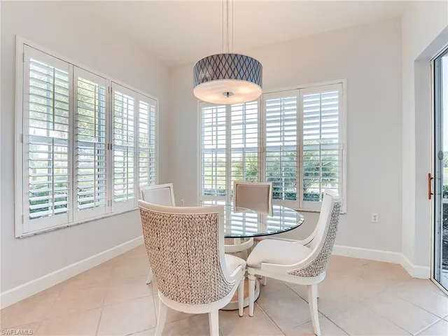 a kitchen with stainless steel appliances granite countertop a stove a kitchen island a dining table and chairs