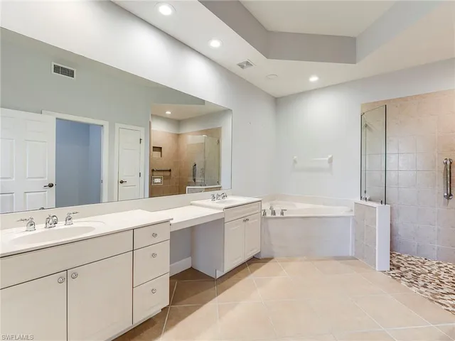 a bathroom with a tub a sink and mirror