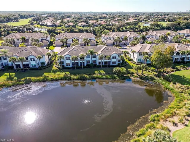 an aerial view of residential houses with outdoor space and parking