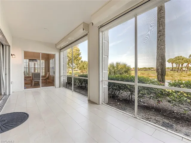 a living room with furniture and floor to ceiling windows