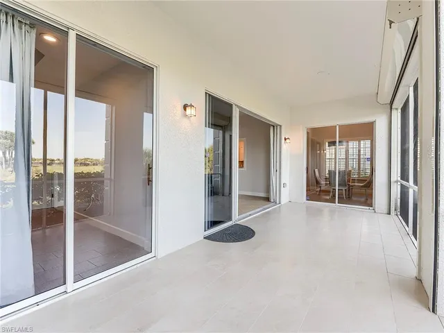 a view of a hallway with wooden floor and a living room