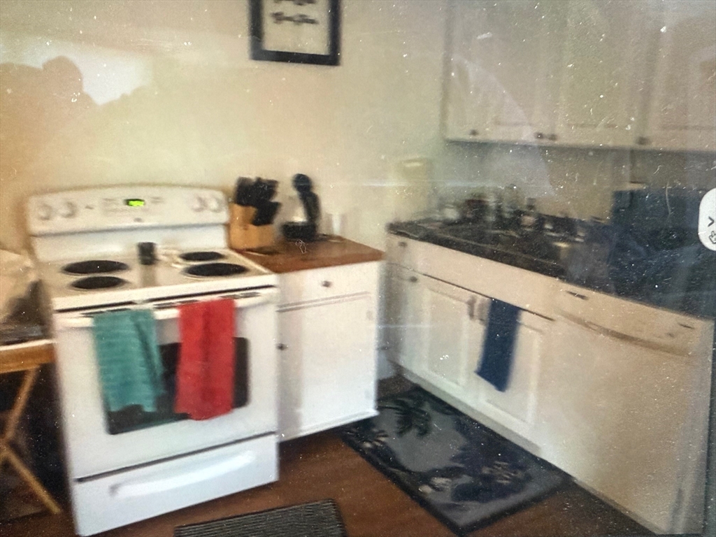 73 Kinsley Street, Unit B Nashua, NH 03060 - Photo 2 of 4 a kitchen with stove and cabinets