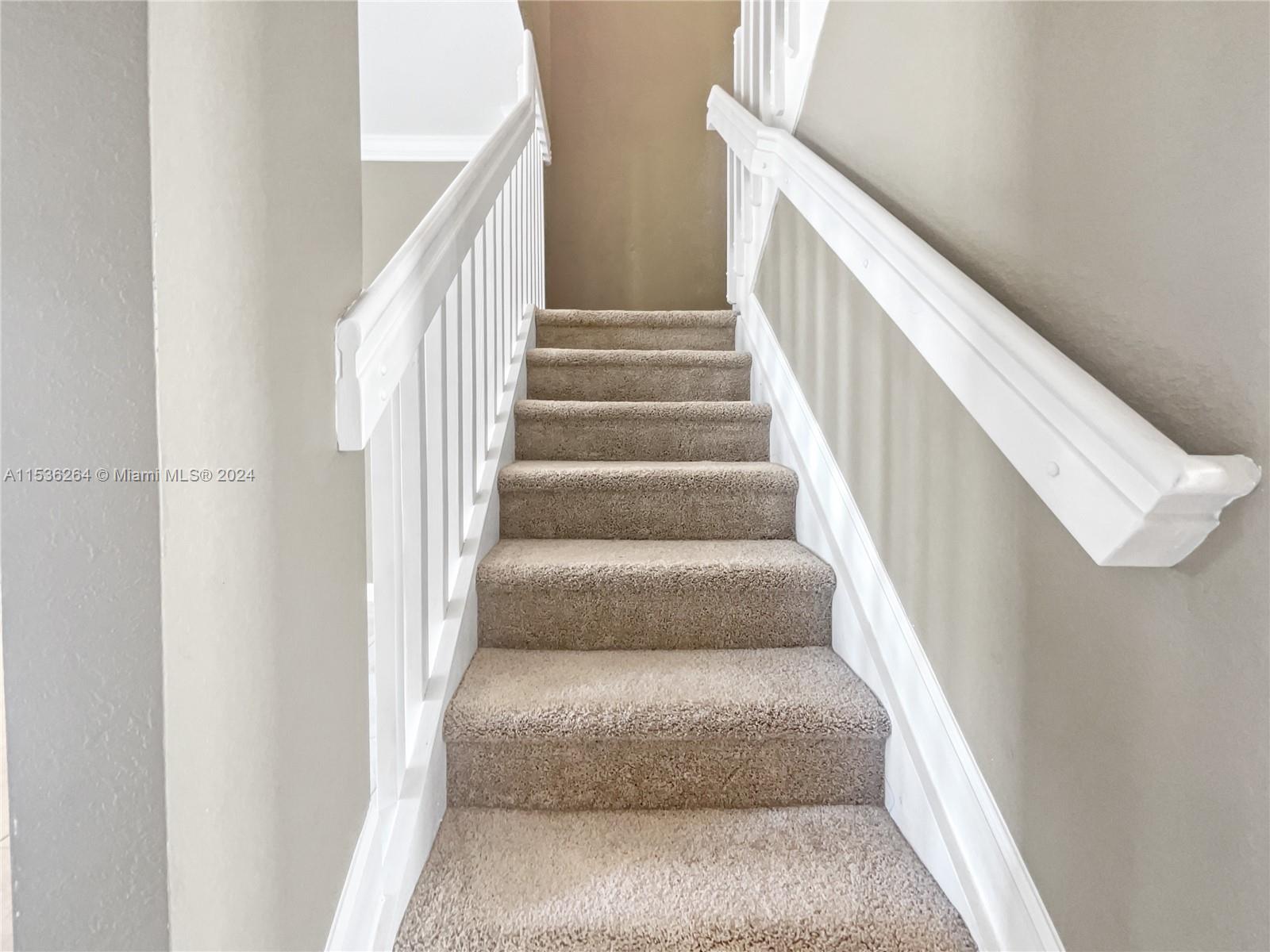 11351 Southwest 240th Street, Unit 1 Homestead, FL 33032 - Photo 11 of 24 a view of staircase with lots of frames on wall and wooden floor