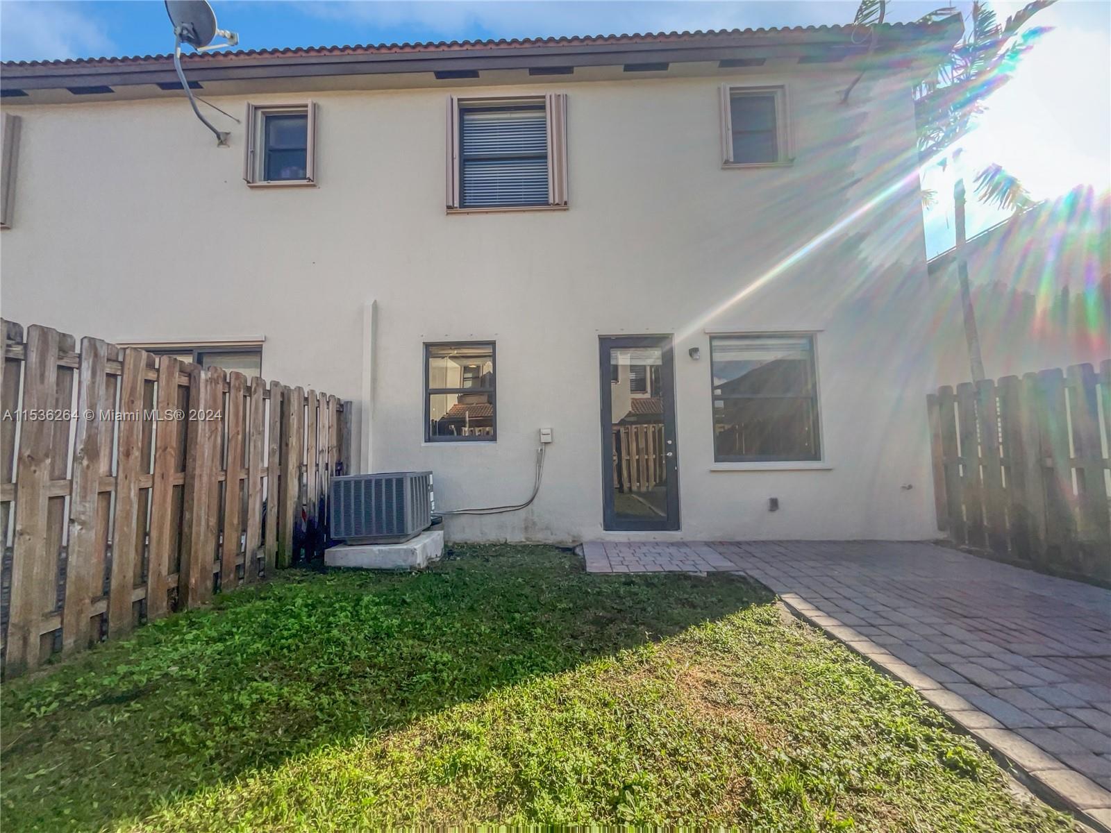 11351 Southwest 240th Street, Unit 1 Homestead, FL 33032 - Photo 22 of 24 a view of a backyard with potted plants and wooden fence