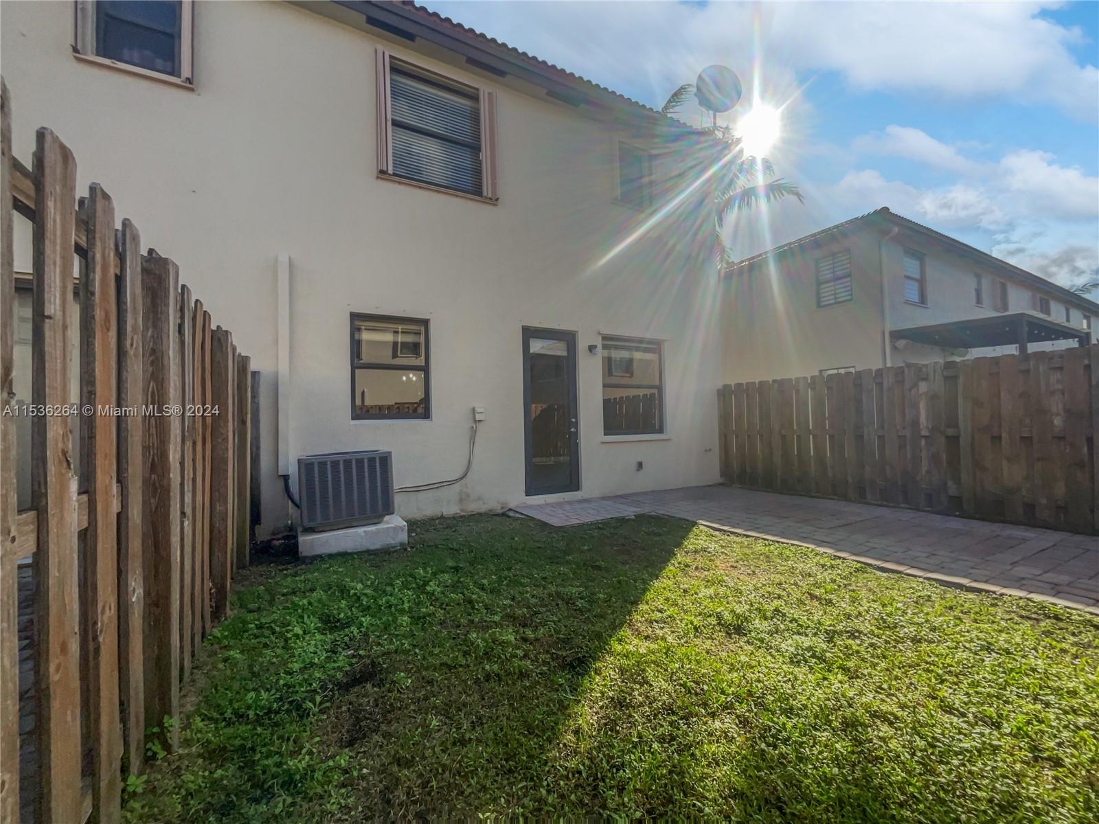 11351 Southwest 240th Street, Unit 1 Homestead, FL 33032 - Photo 23 of 24 a view of a backyard with potted plants and wooden fence