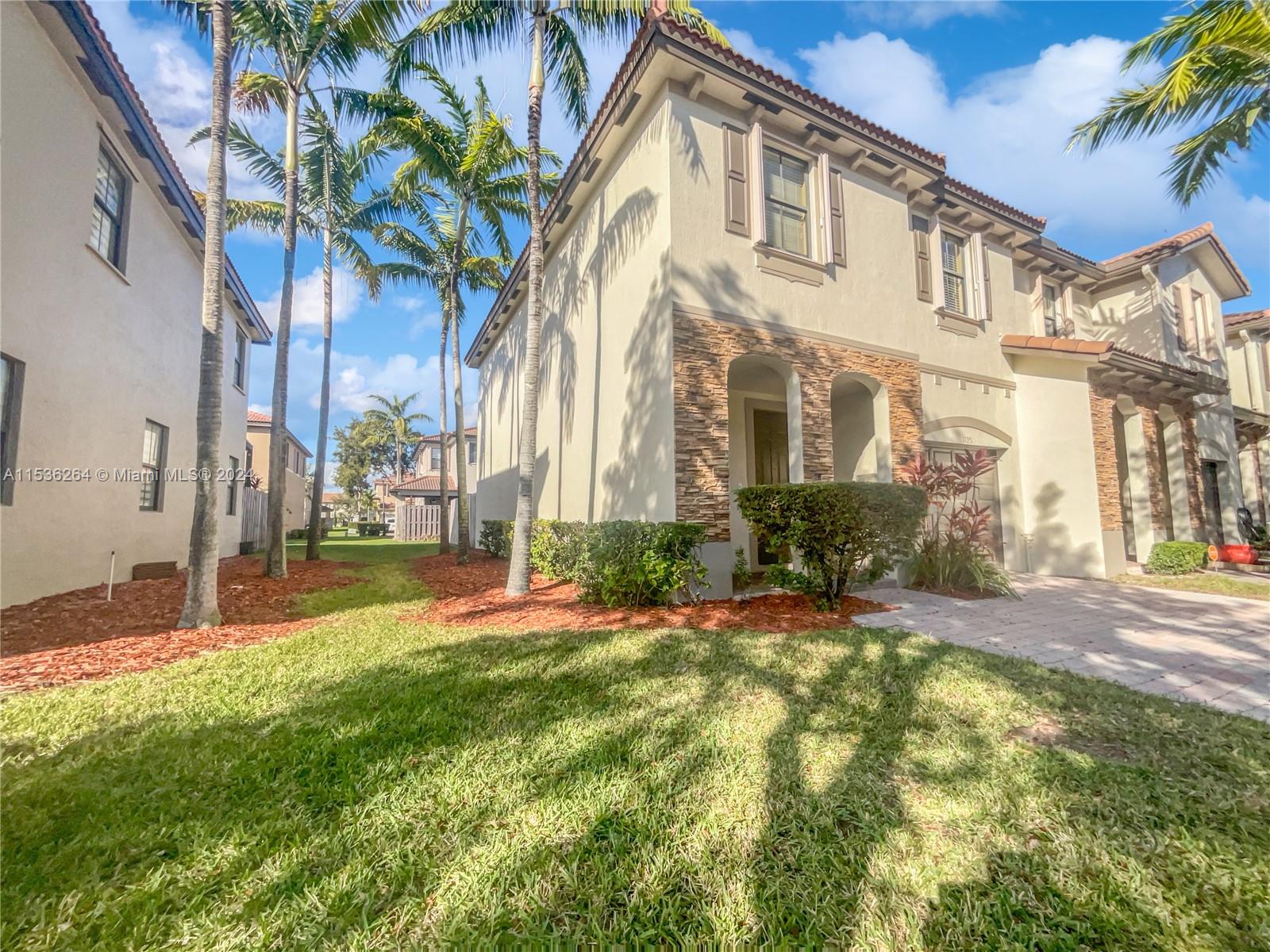 11351 Southwest 240th Street, Unit 1 Homestead, FL 33032 - Photo 24 of 24 a view of a big house with a big yard and large trees
