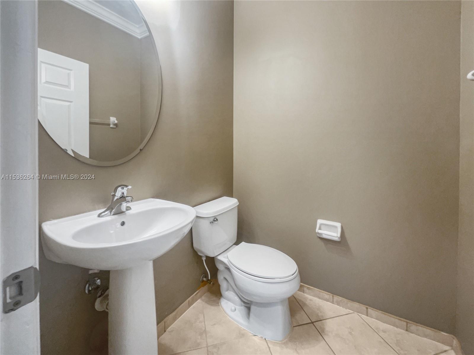 11351 Southwest 240th Street, Unit 1 Homestead, FL 33032 - Photo 6 of 24 a bathroom with a sink and mirror