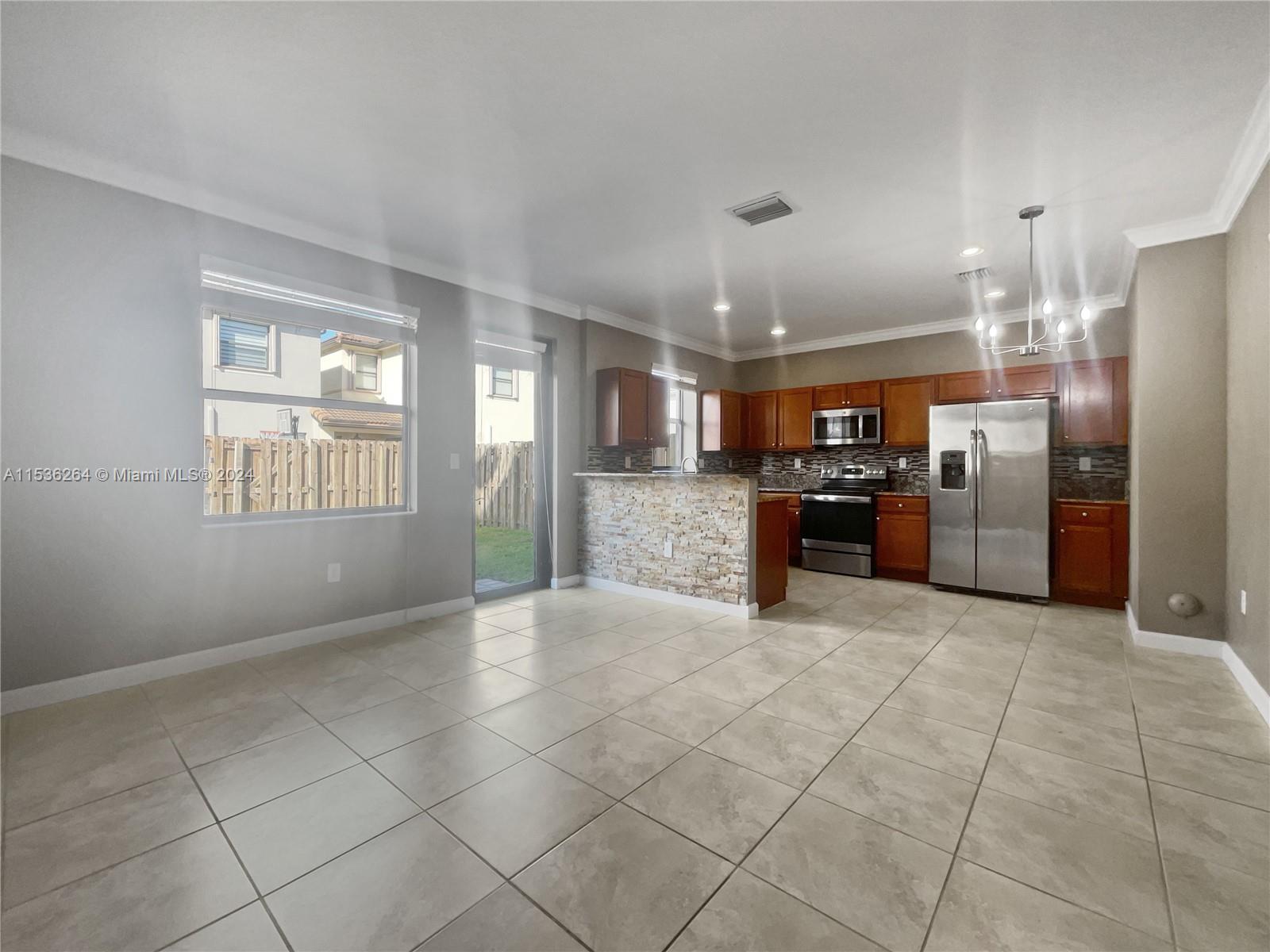 11351 Southwest 240th Street, Unit 1 Homestead, FL 33032 - Photo 7 of 24 a large kitchen with cabinets and stainless steel appliances