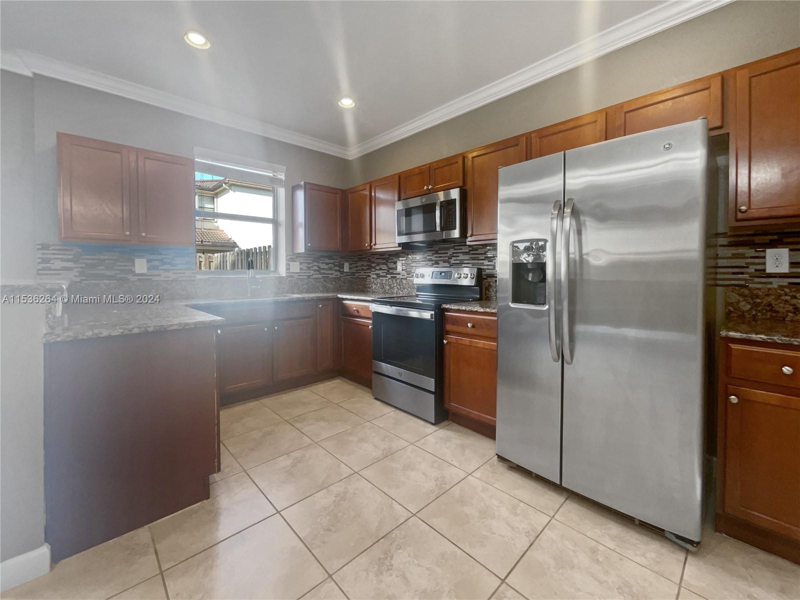 11351 Southwest 240th Street, Unit 1 Homestead, FL 33032 - Photo 9 of 24 a kitchen with stainless steel appliances granite countertop a refrigerator and a sink