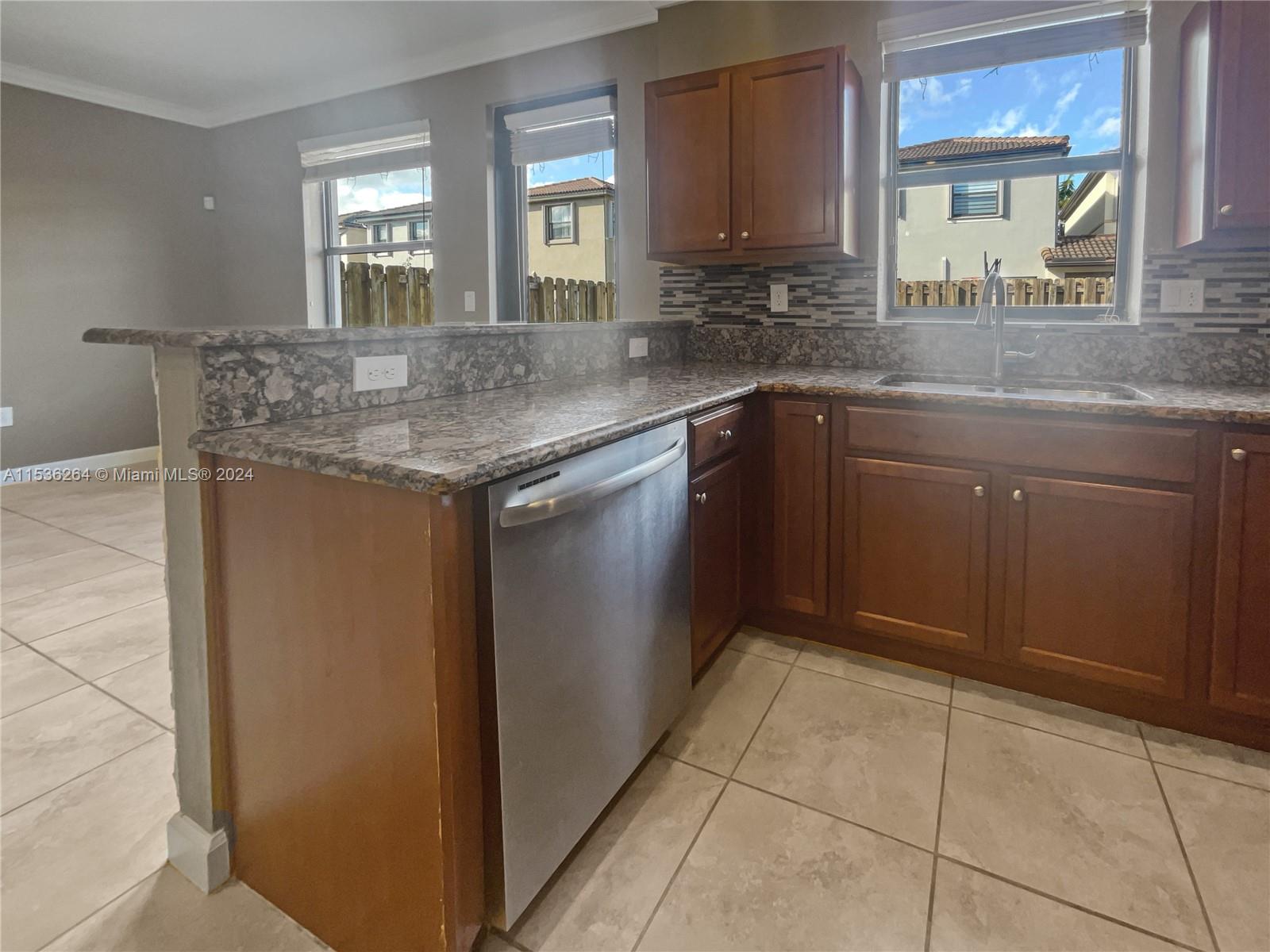 11351 Southwest 240th Street, Unit 1 Homestead, FL 33032 - Photo 10 of 24 a kitchen with a sink window and cabinets