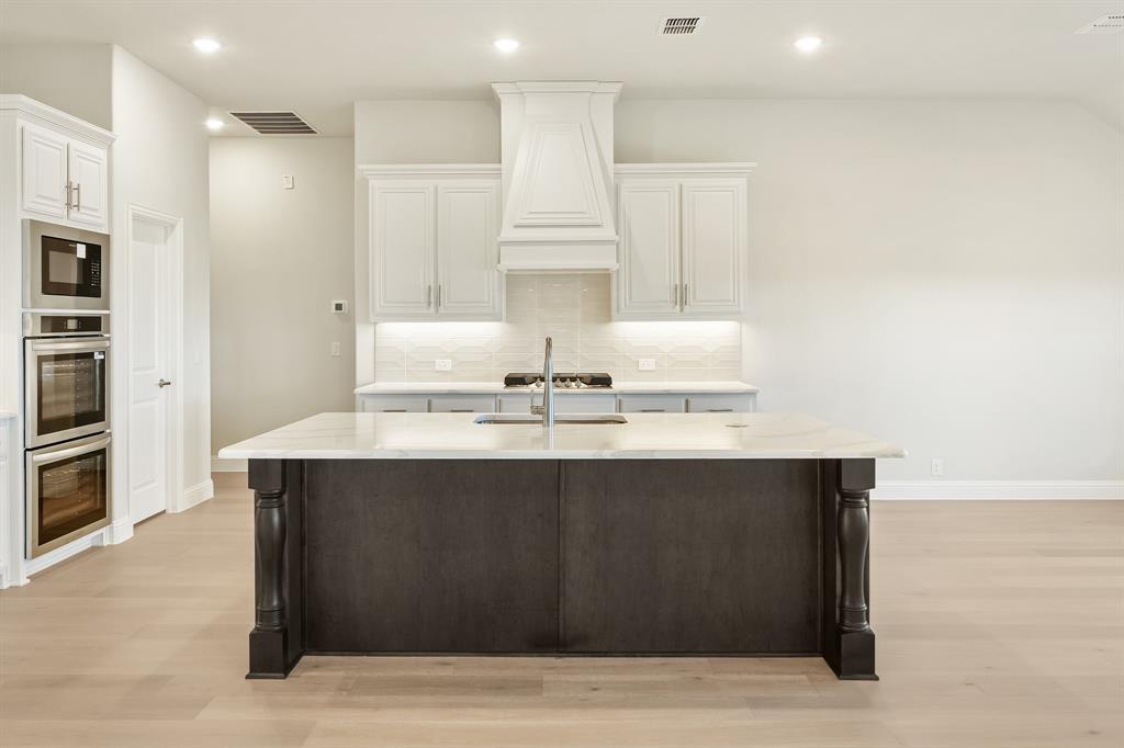 1024 Silver Sage Drive Justin, TX 76247 - Photo 14 of 35 a kitchen with stainless steel appliances a sink dishwasher and a refrigerator with wooden floor