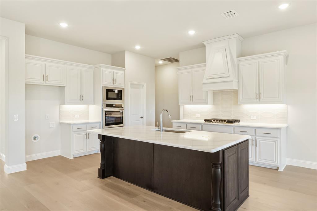 1024 Silver Sage Drive Justin, TX 76247 - Photo 15 of 35 a kitchen with a sink a stove a refrigerator and white cabinets