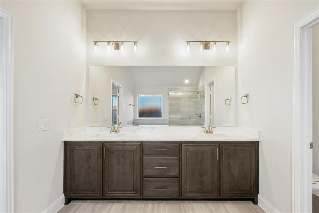 1024 Silver Sage Drive Justin, TX 76247 - Photo 25 of 35 a bathroom with a granite countertop sink a large mirror and a