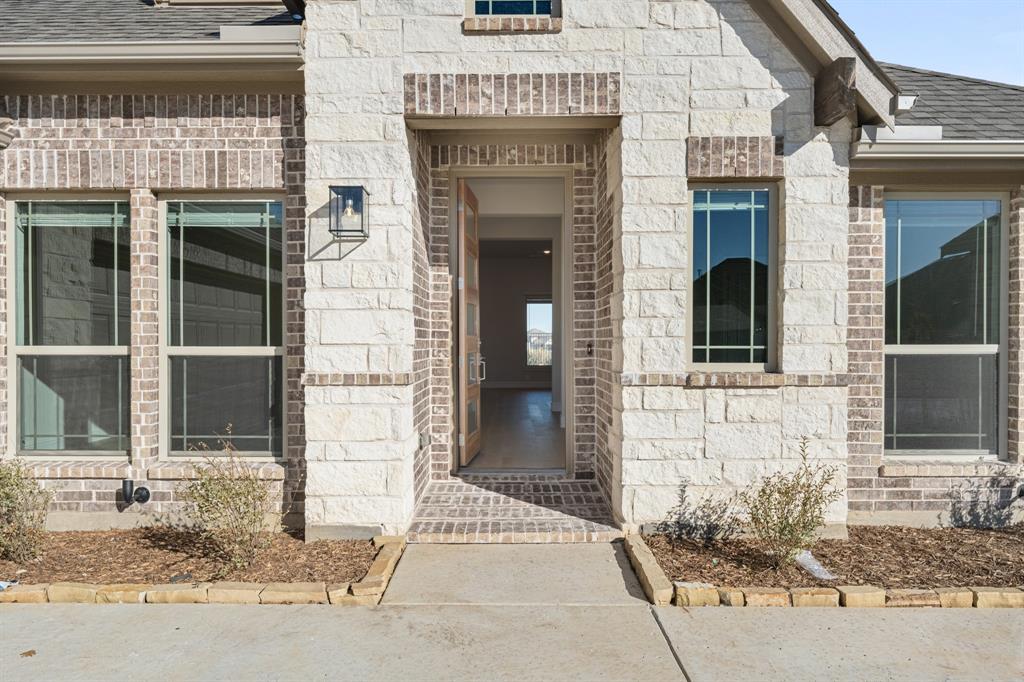 1024 Silver Sage Drive Justin, TX 76247 - Photo 4 of 35 a front view of a house with a garden