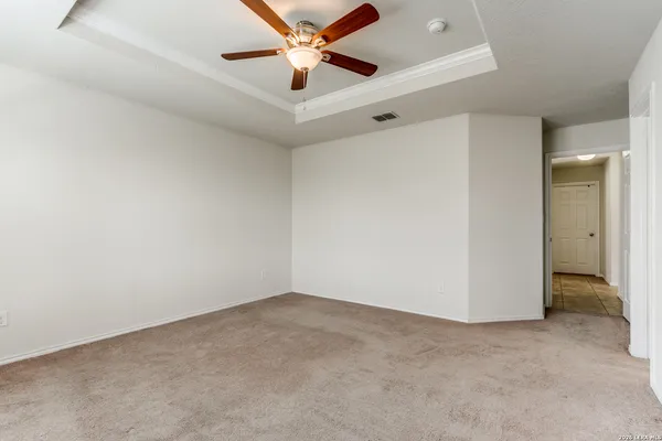 an empty room with closet and a chandelier fan