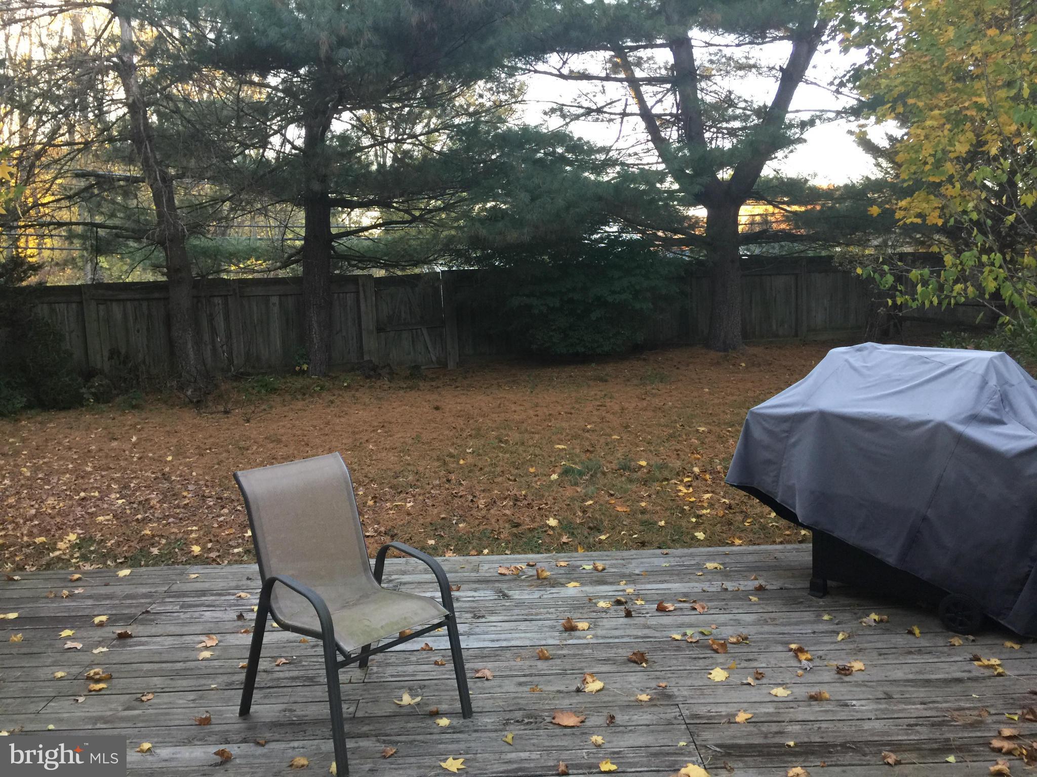 18801 Lindenhouse Road Gaithersburg, MD 20879 - Photo 20 of 22 a view of a backyard with table and chairs with wooden fence and plants