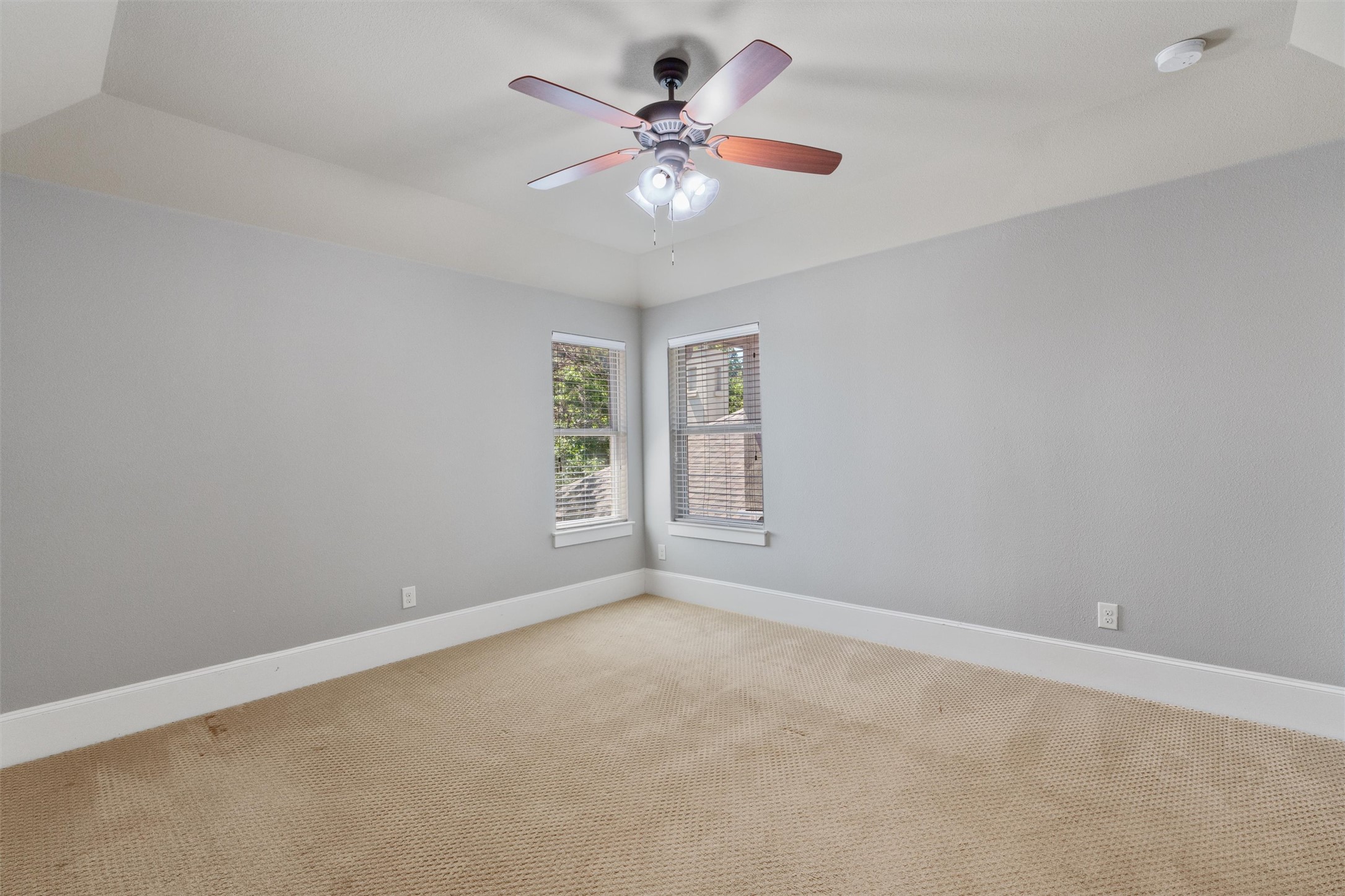 8417 Etienne Cove Austin, TX 78759 - Photo 24 of 35 Well-lit sleeping quarters with a vaulted ceiling and corner window views.