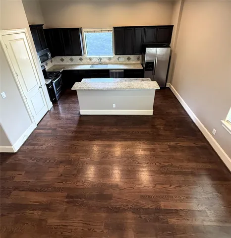 a view of appliances in kitchen and an empty room
