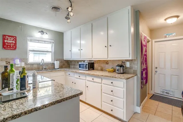 a kitchen with granite countertop a sink stainless steel appliances and cabinets