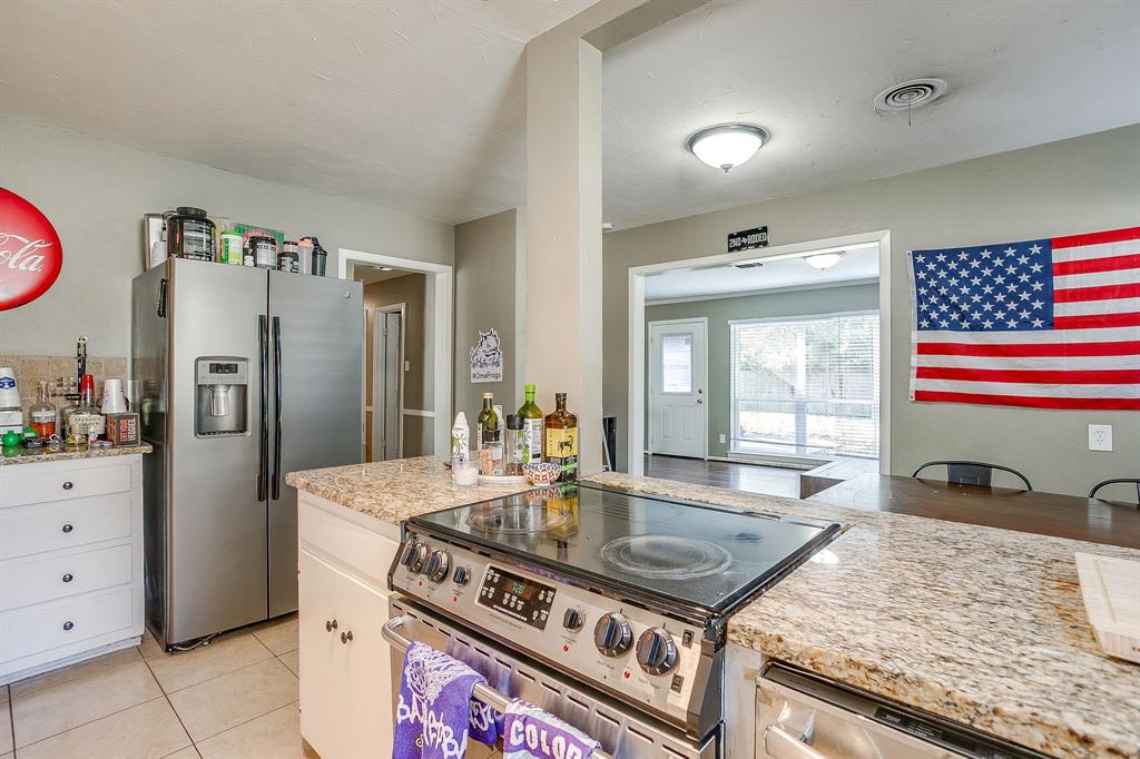 3612 Winston Road Fort Worth, TX 76109 - Photo 18 of 40 a kitchen with granite countertop a stove a refrigerator and a sink