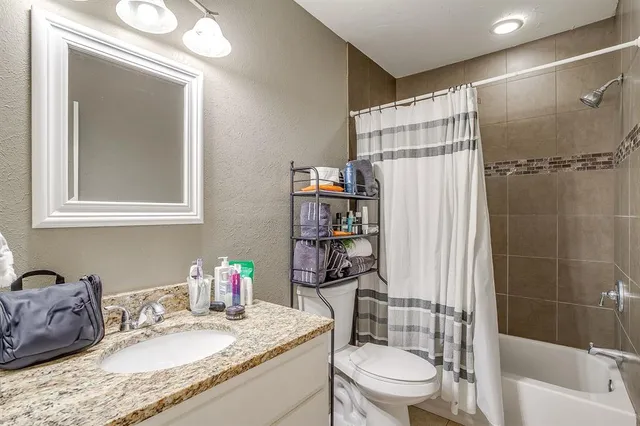 a bathroom with a granite countertop sink toilet and shower