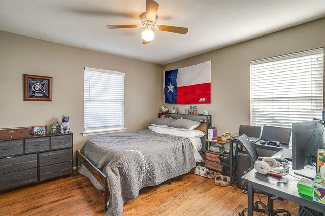 a bedroom with a bed dresser and wooden floor