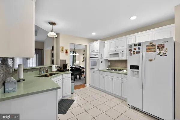 a kitchen with kitchen island white cabinets and refrigerator