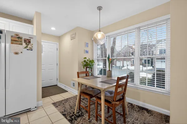 a dining room with furniture potted plants and wooden floor