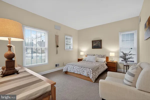 a spacious bedroom with a bed and large windows