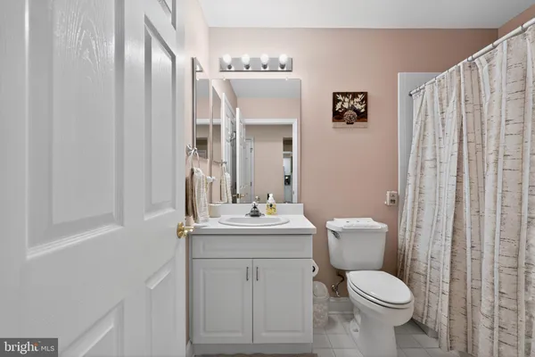 a bathroom with a sink vanity mirror and toilet