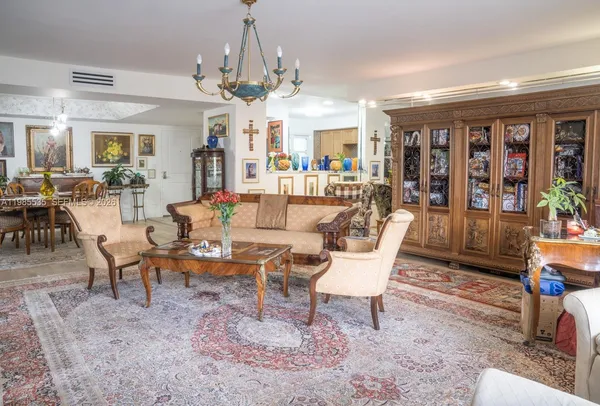 a living room with furniture a chandelier and a dining table