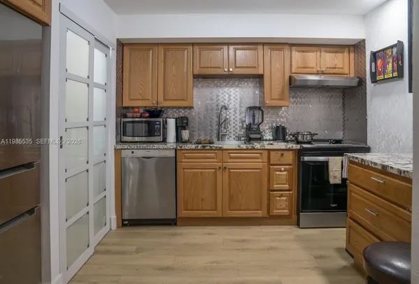 a kitchen with stainless steel appliances granite countertop a stove and a refrigerator