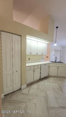 a large white kitchen with a sink a refrigerator and a stove