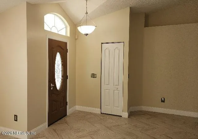 an empty room with mirror closet and a bathroom