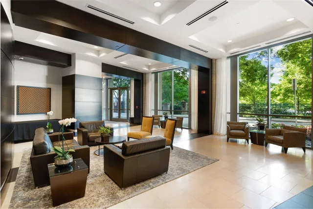 a living room with furniture and floor to ceiling windows