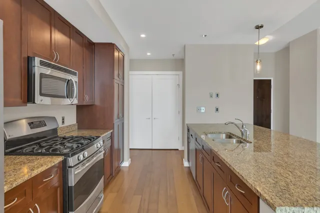 a kitchen with stainless steel appliances granite countertop a stove a sink and a refrigerator