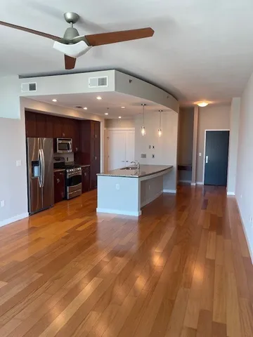 a view of a kitchen with kitchen island a counter top space appliances and cabinets