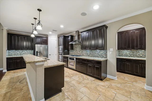 a kitchen with stainless steel appliances kitchen island granite countertop a stove top oven and sink
