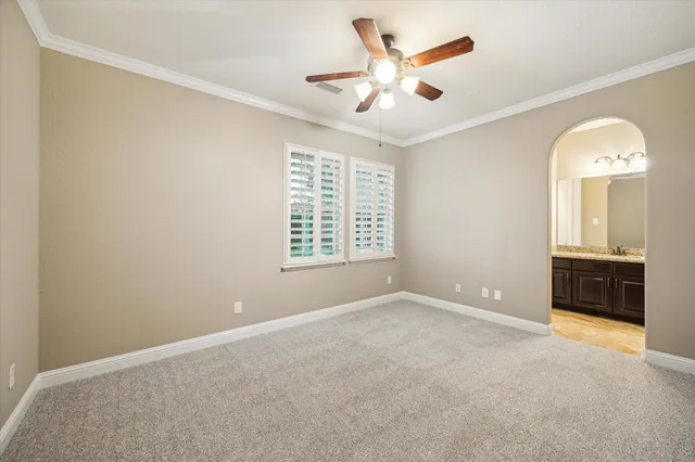 an empty room with a ceiling fan and a window