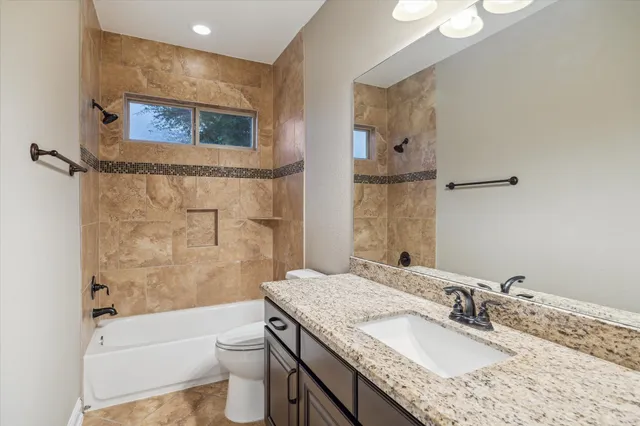 a bathroom with a granite countertop sink toilet and shower