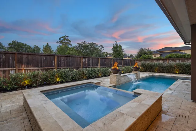 a view of a swimming pool with a patio and a garden