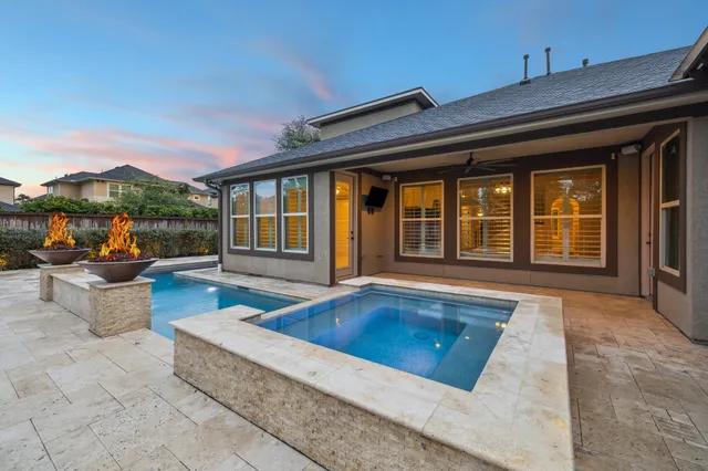 a view of a house with swimming pool and sitting area