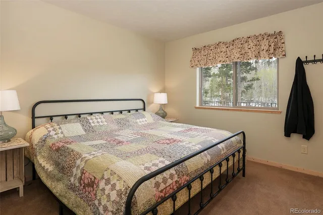 a bedroom with a bed window and flat screen tv